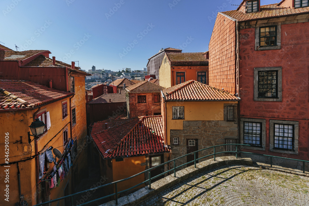 Red and orange color houses in European city view. Porto, Portugal, small casual streets in old center
