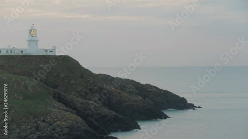 View of lighthouse on cloudy evening. Pan across and past. Strumble Head Lighthouse. photo