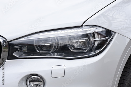 shiny headlight on a  white car © Laurenx