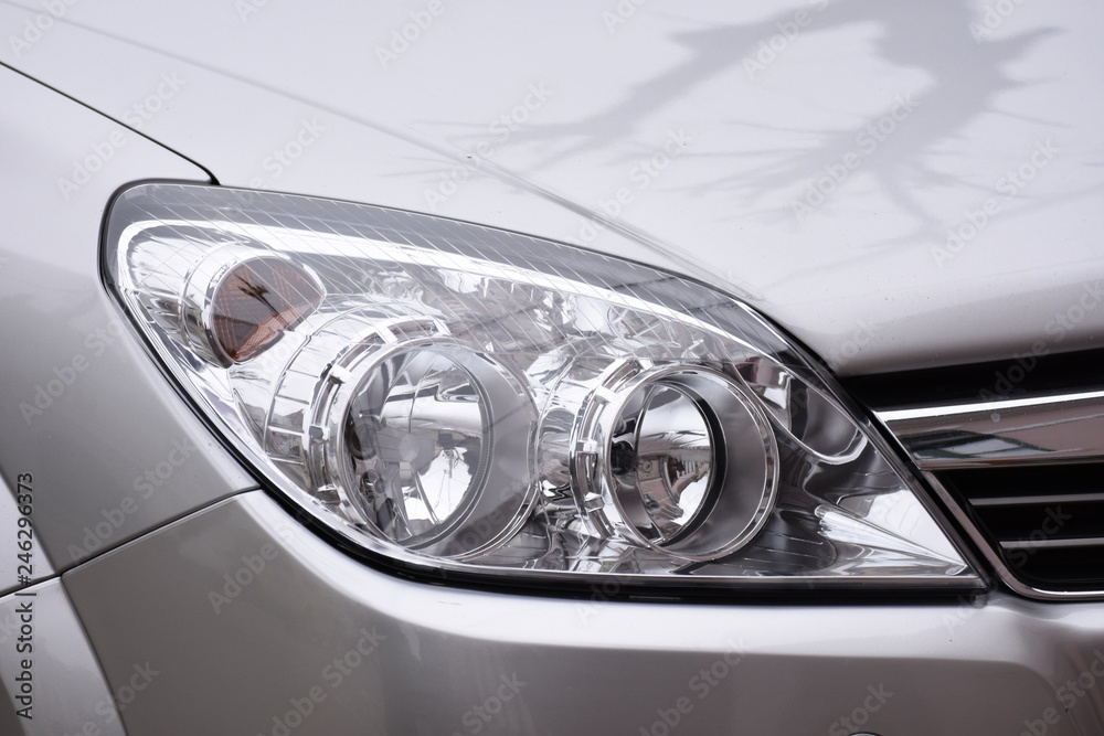 shiny headlight on a  silver  car
