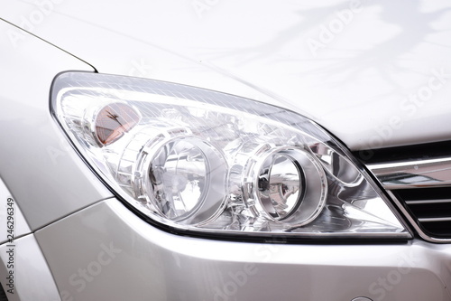 shiny headlight on a  white car © Laurenx