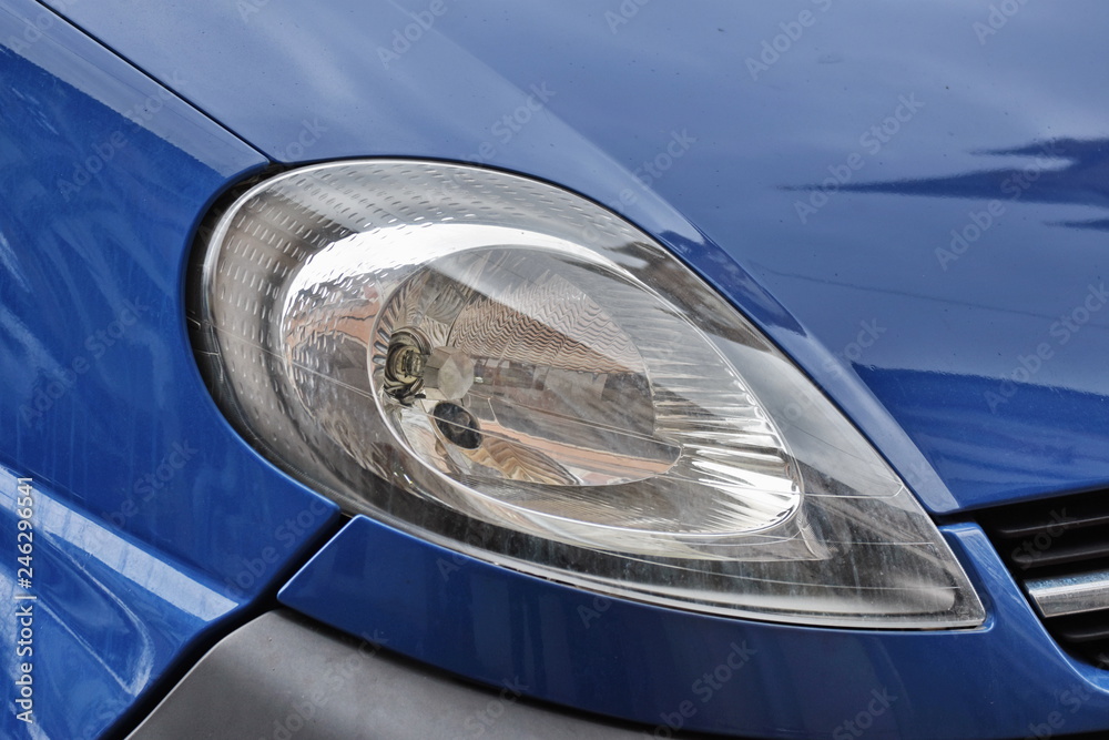 shiny headlight on a  white blue  car