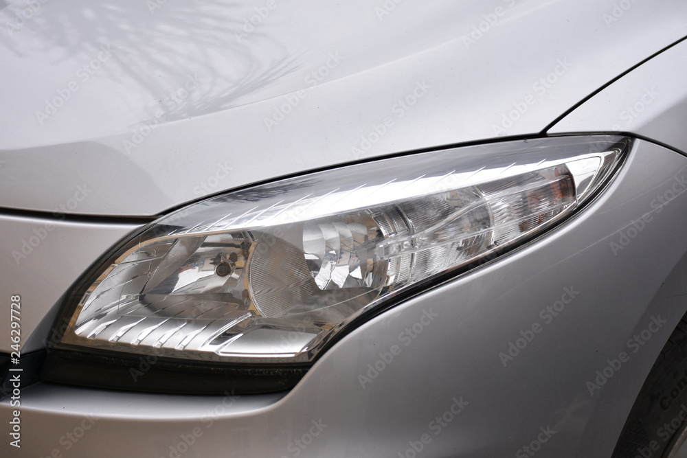 shiny headlights on a white silver car