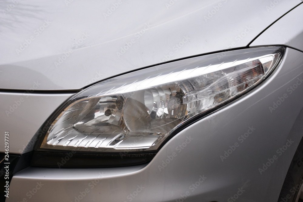 shiny headlights on a white silver car - obrazy, fototapety, plakaty 