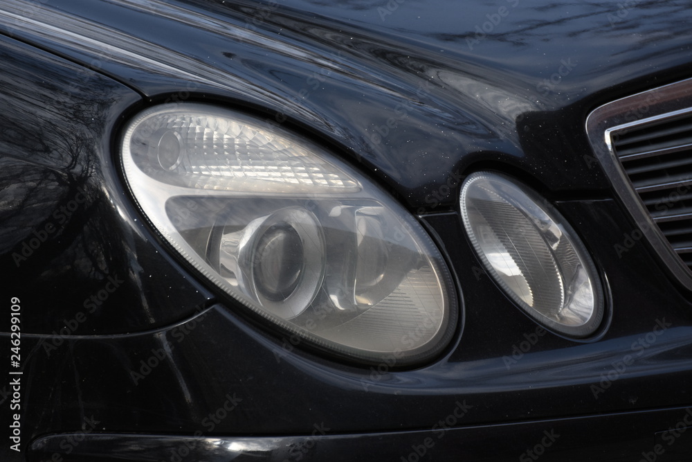 Car'sCar exterior detail.shiny headlight on a black  car exterior detail, headlight on a  new car