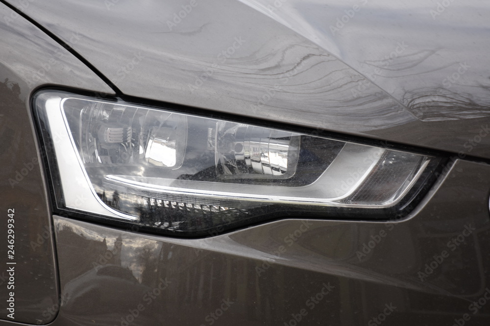 Car's exterior detail, headlight on a  brown  car