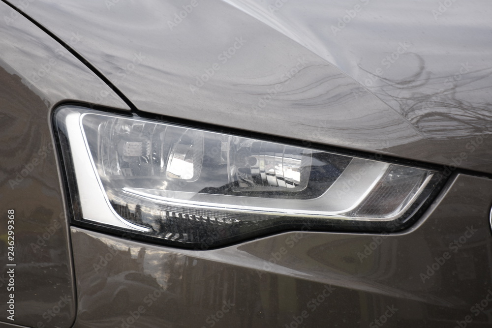 Car's exterior detail, headlight on a  brown  car