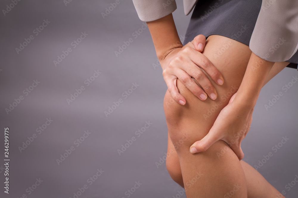 woman with knee joint pain symptoms, closeup hand holding injured knee; portrait of asian woman suffering from knee pain injury with surgical cut scar; tan skin asian young adult woman model woman with knee joint pain symptoms, closeup hand holding injured knee; portrait of asian woman suffering from knee pain injury with surgical cut scar; tan skin asian young adult woman model