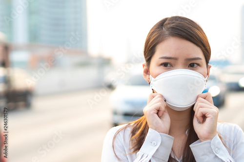 Plakat City air pollution concept. Close up woman wearing N95 mask to protect pm2.5 air pollution in city