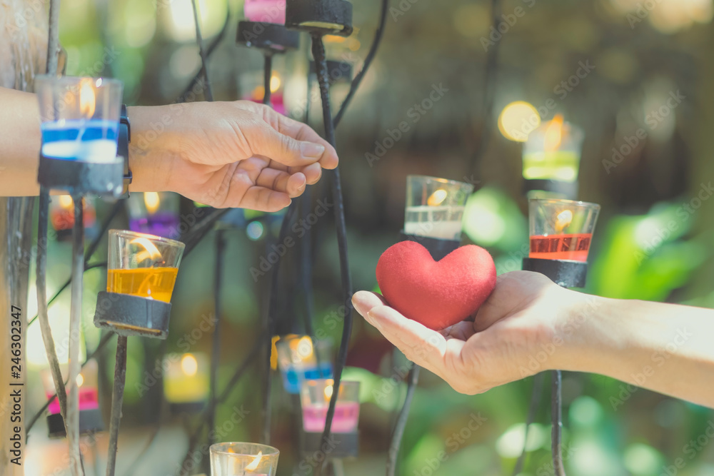 Romantic couple on valentines day. Happy joyful woman giving man heart shape little pillow in a candle light.In the afternoon, Love concept. Romantic couple on valentines day. Happy joyful woman giving man heart shape little pillow in a candle light.In the afternoon, Love concept.