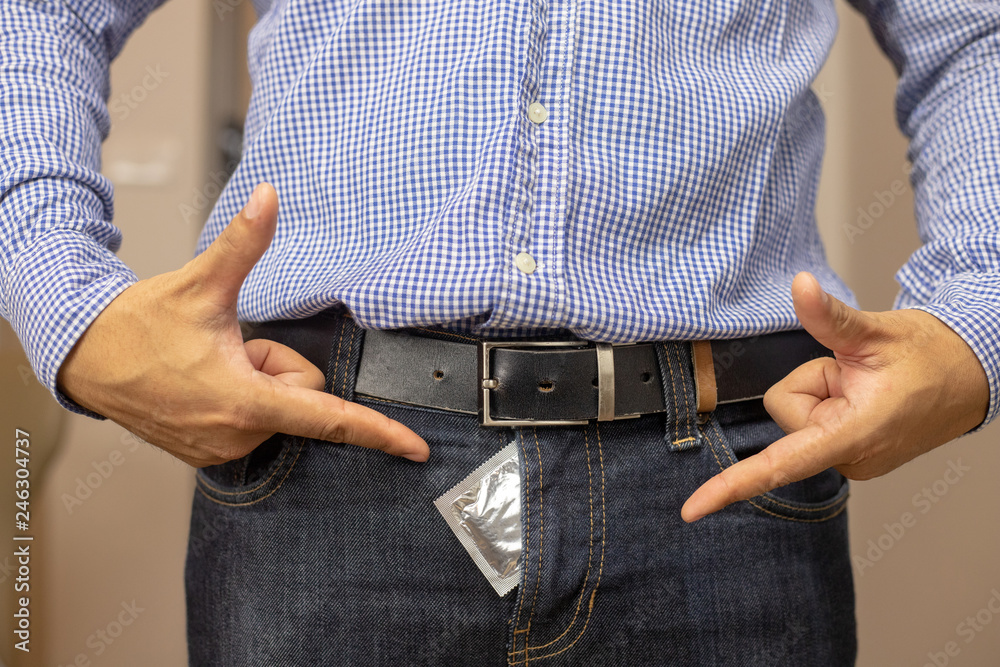 Men use two hands to point the condom at the crotch. Stock Photo | Adobe  Stock