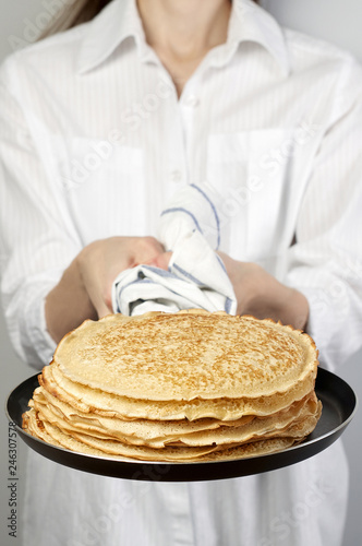 Obraz na płótnie Stack of russian pancake blini in pan woman holds in hands w salonie