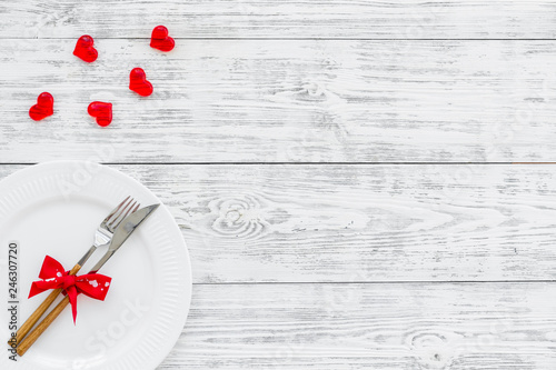 Dating in the restaurant on Valentine's day. Decorated dishes on white wooden background top view copy space