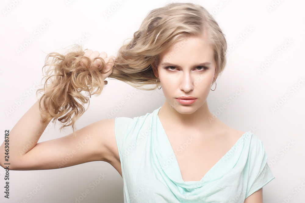 portrait of a young woman holding her long curly healthy hair portrait of a young woman holding her long curly healthy hair