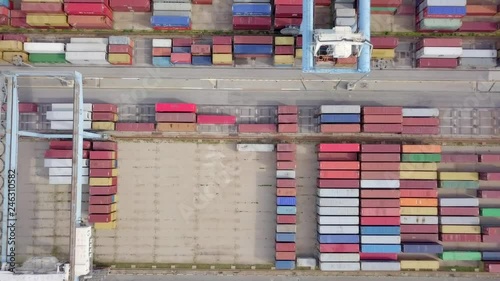 Transtainer yard - Various brands and colours of Shipping containers stacked by Transtainers (Mobile gantry cranes) off of service trucks - Top down aerial footage. photo