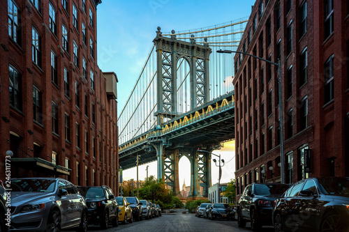 Manhattan bridge seen from a narrow alley enclosed by two brick buildings photo