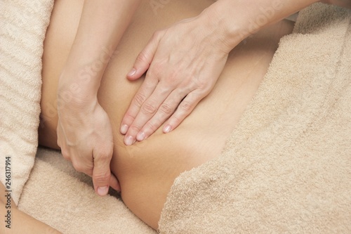 massage therapist doing a thermic massage for the abdomen for a woman