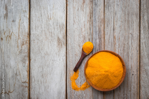 Turmeric powder and roots on wooden background, asian herb for medication, flay lay concept photo