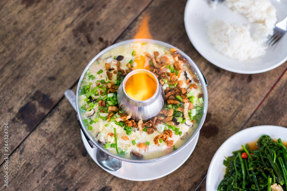Steamed Egg (Kai thoon) with eggs, pork, meat and vegetables in pot with fire Steamed Egg (Kai thoon) with eggs, pork, meat and vegetables in pot with fire