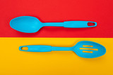 Plastic kitchen tools isolated on yellow-red background