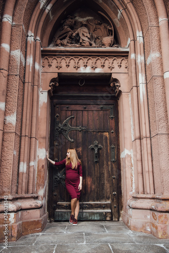Pregnant girl blonde in burgundy dress. In the big city. Long hair. 9 months waiting. Happiness to be a mother. Against the backdrop of a beautiful old building. © malysheva