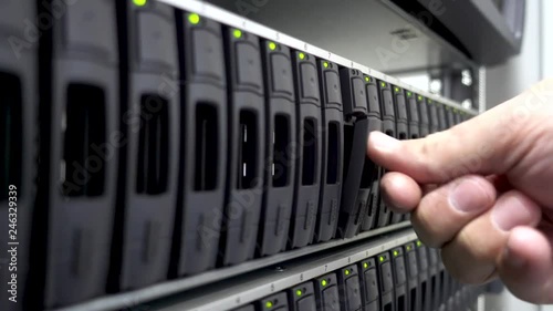 Working Data Center IT Engineer Installs Hard Drive into Server Rack. 4K.Working Hard Drives. Concept 3.0