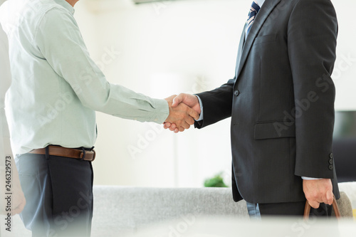 中年夫婦と握手するビジネスマン