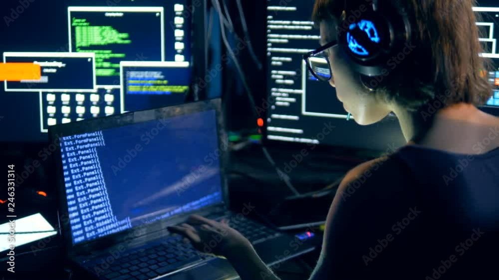 Girl types on a laptop, hacking system. Cyber crime and hacking concept.