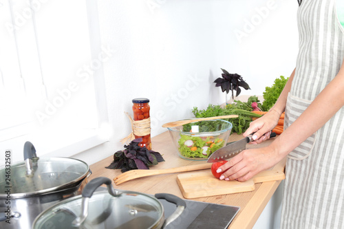 Fototapeta Naklejka Na Ścianę i Meble -  Fresh vegetables on the cutting board, salad in a glass dish. Concept of cooking