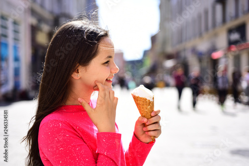 Nice and creamy. Pretty girl hold ice cream cone on summer day. Enjoying frozen food snack or dessert. Happy girl child eating ice cream in hot weather. Cute girl smiling with ice cream