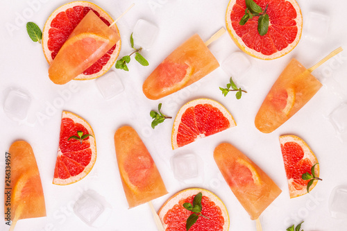Fototapeta Naklejka Na Ścianę i Meble -  Homemade grapefruit popsicle with ripe grapefruit slices and fresh mint