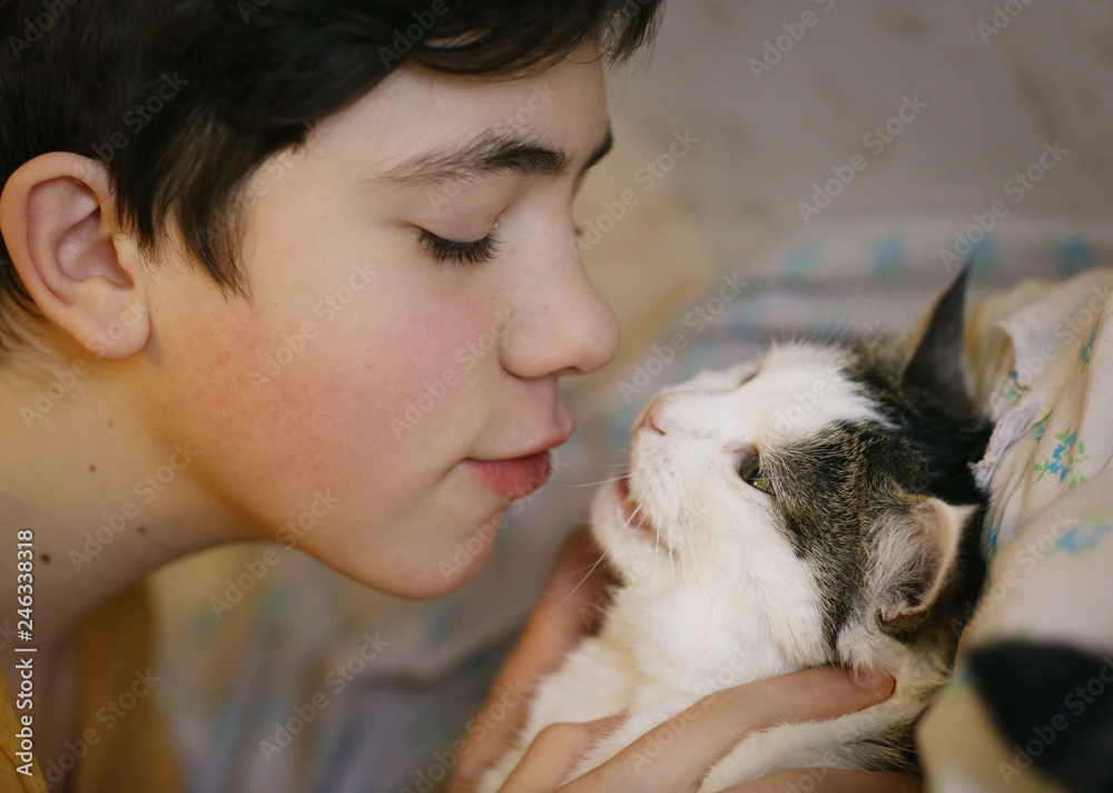teenager boy with cat kissing hug photo