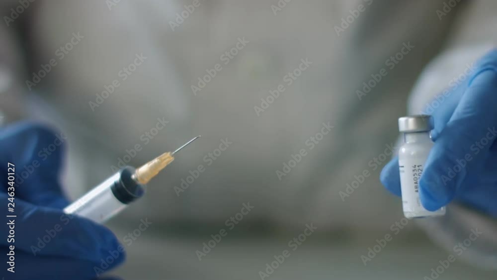 Nurse shakes vial of vaccine Nurse shakes vial of vaccine