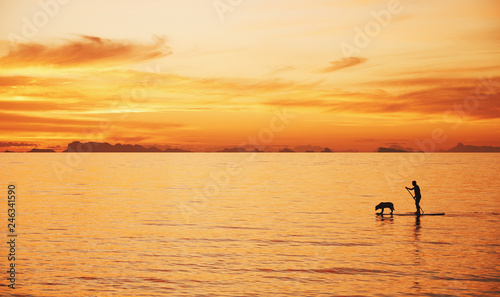 Man with dog on a sea in the sunrise. Thailand, Phangan © spaxiax