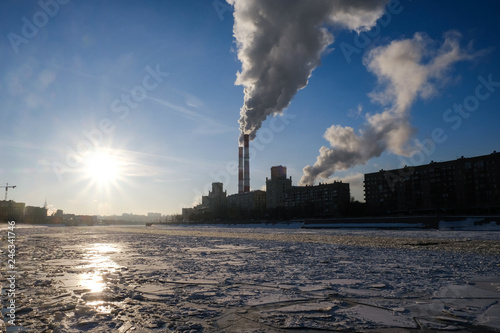 Photography Smoke from heating system chimney close to the frozen Moscva river in Moscow dur