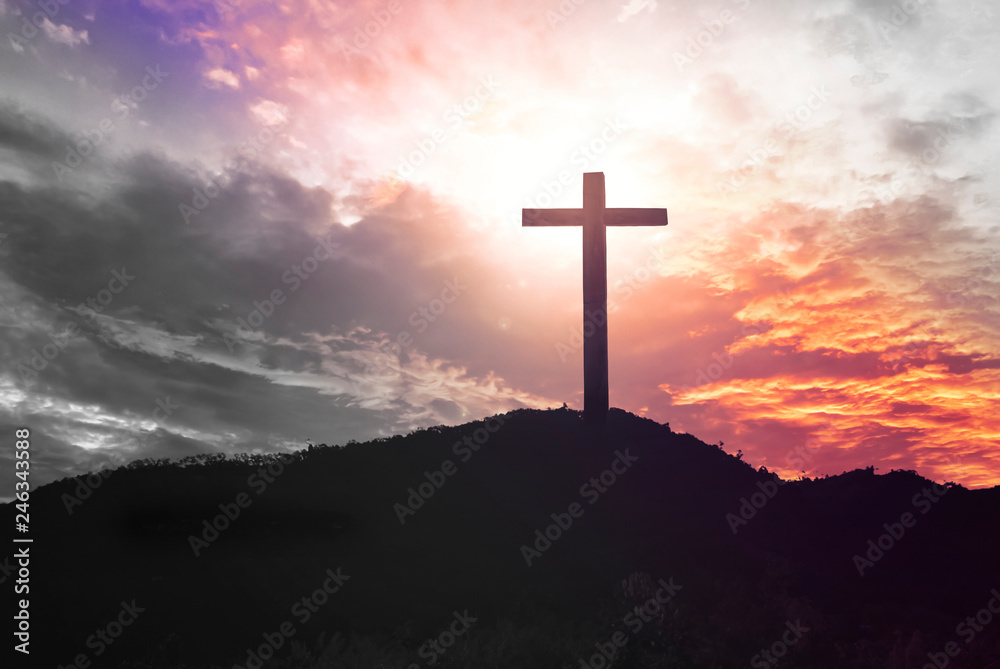  Concept of Jesus Christ: white cross on sunset sky background