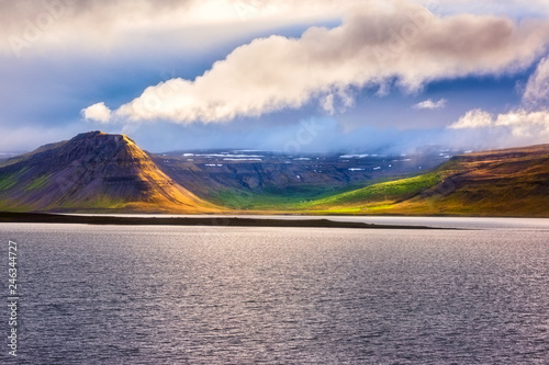 Amazing nature, scenic day time landscape with water, volcanic mountains and cloudy sky, Iceland. Travel outdoor summer background
