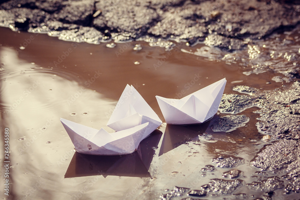 The paper boat floats through the spring puddles. Children's entertainment. The paper boat floats through the spring puddles. Children's entertainment.
