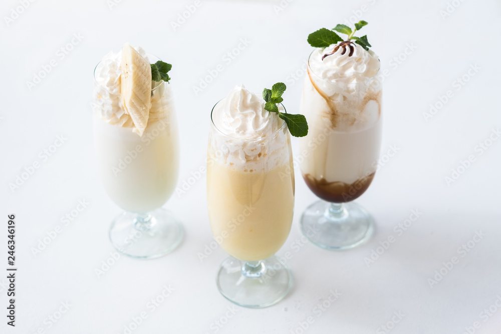 Assorted milkshakes set. Minimal layout. Three glasses on white background.
