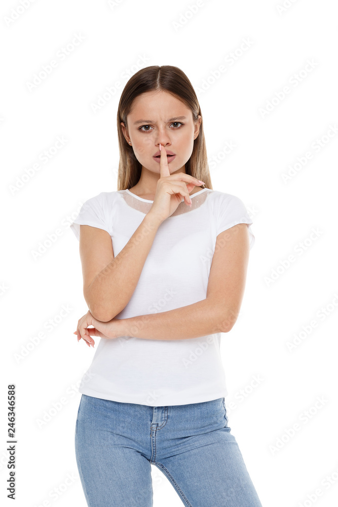 The girl holds a straight finger near the mouth. Call for silence The girl holds a straight finger near the mouth. Call for silence
