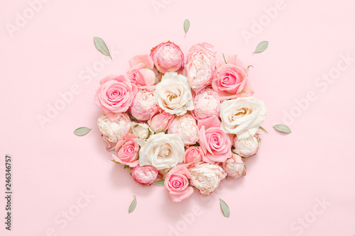 Fototapeta Naklejka Na Ścianę i Meble -  Greeting flower composition. Assorted roses on pink background. Minimal leaves layout.