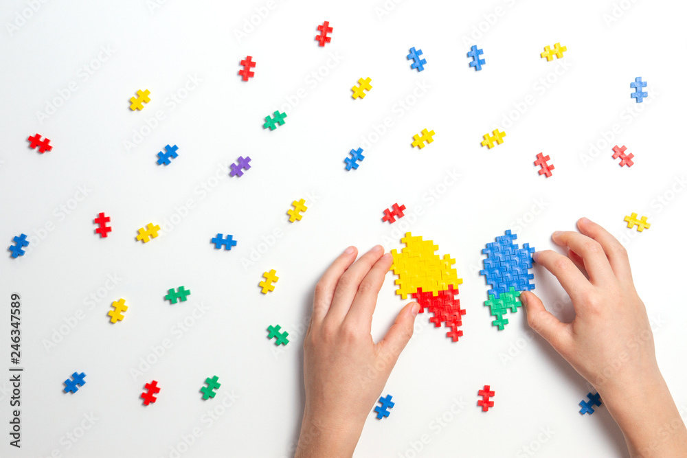 Child hands making multicolor heart on white background. Top view Child hands making multicolor heart on white background. Top view