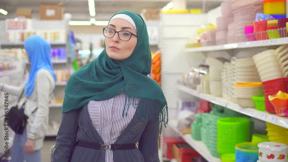 Portrait young muslim woman in hijab in the supermarket in the department of household goods Portrait young muslim woman in hijab in the supermarket in the department of household goods
