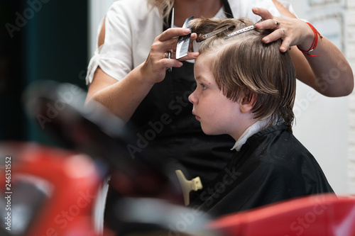 A young boy gets a haircut in a children's hairdresser
