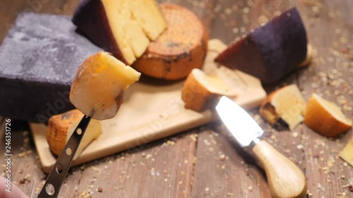 Food video. Top view shot on vatiety of hard delicious cheese placed on wooden cutting board. Restaurant luxury food concept. A cheese knife with a delicious piece of cheese. hd photo