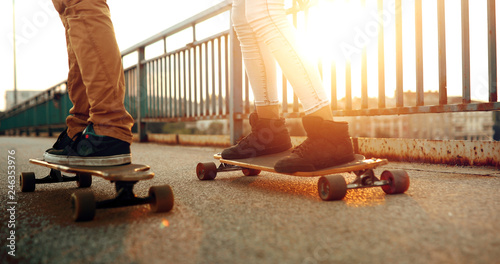 Young attractive couple riding skateboards and having fun photo
