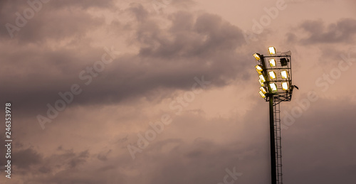 Bright sports stadium lights on a cloudy evening