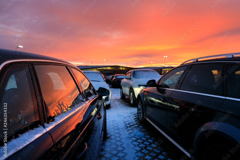 Cars on the parking lot on the background of the red sunset