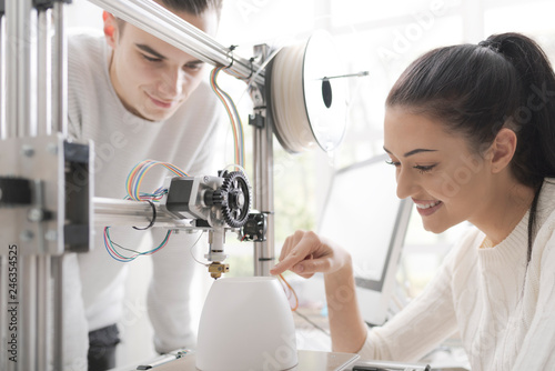 Engineering students using a 3D printer in the lab