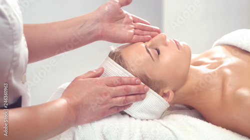 Young attractive woman getting spa treatment over white background. © Acronym